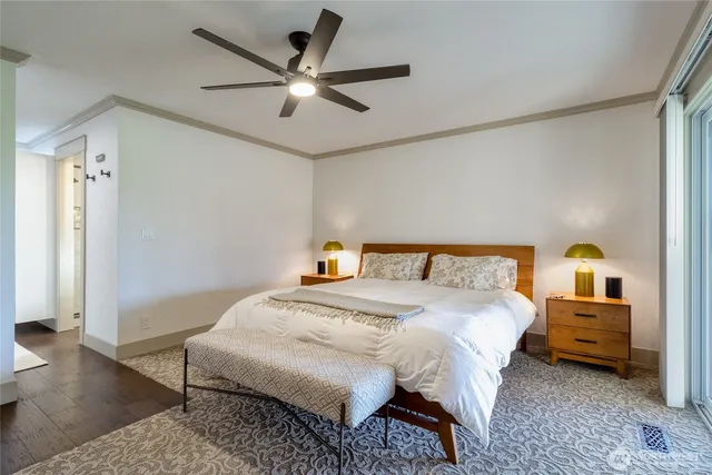 a bedroom with a bed a ceiling fan and a rug