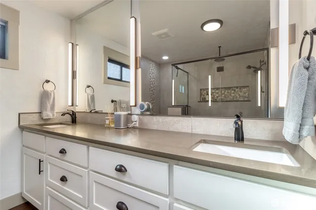 a bathroom with double vanity sink and mirror