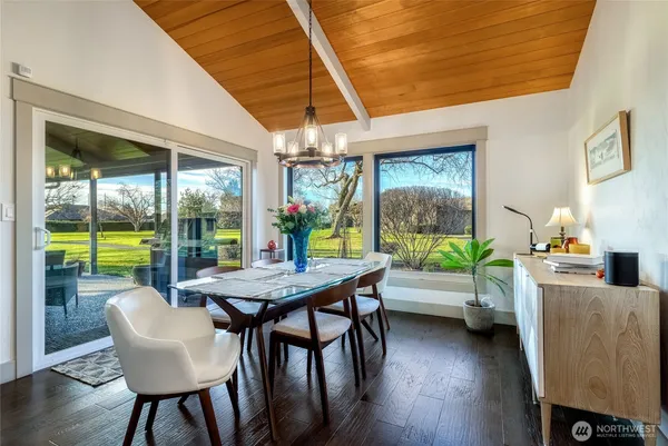 a dining room with furniture a chandelier and wooden floor