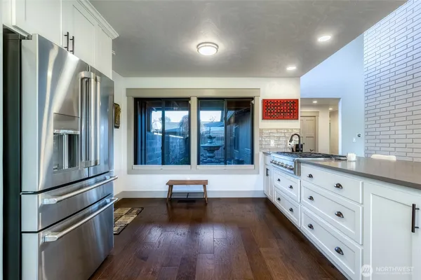a kitchen with granite countertop a refrigerator and a sink