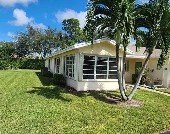a view of a house with backyard and sitting area