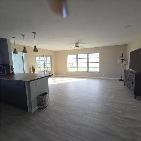 a view of kitchen and hall with wooden floor