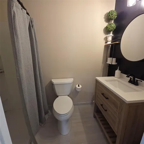 a bathroom with a toilet a sink and a mirror