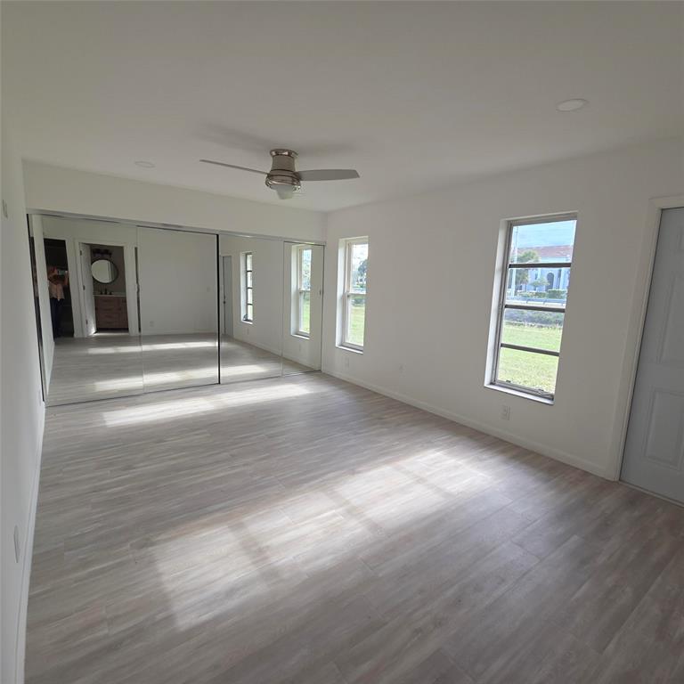 5385 Lake Front Boulevard, Unit A Delray Beach, FL 33484 - Photo 14 of 31 a view of an empty room with chandelier and wooden floor