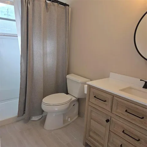 a white toilet sitting next to a white cabinet