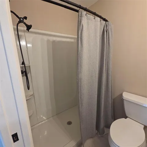 a bathroom with a shower a toilet and a sink