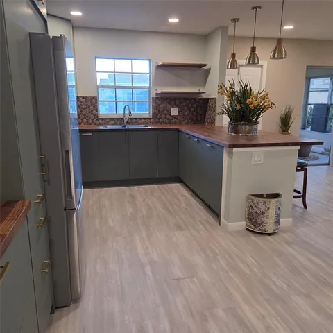 a kitchen with stainless steel appliances a refrigerator sink and wooden floor
