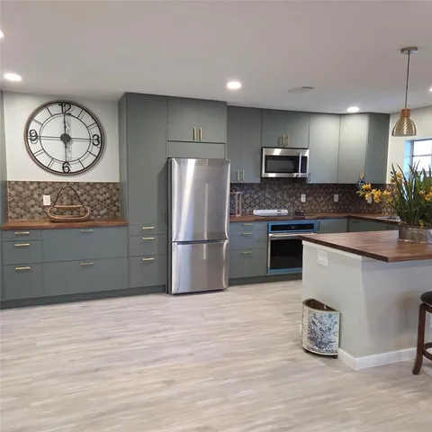 a kitchen with stainless steel appliances granite countertop a refrigerator and a stove top oven
