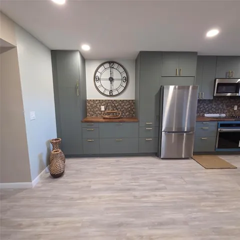 a view of a kitchen with fridge and wooden floor