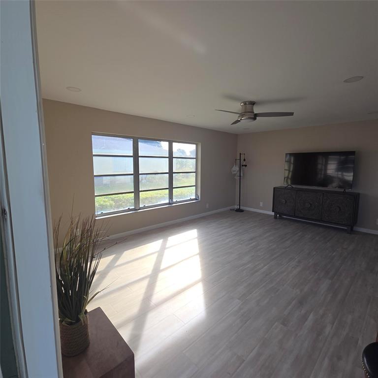 5385 Lake Front Boulevard, Unit A Delray Beach, FL 33484 - Photo 9 of 31 a view of empty room with wooden floor and fan