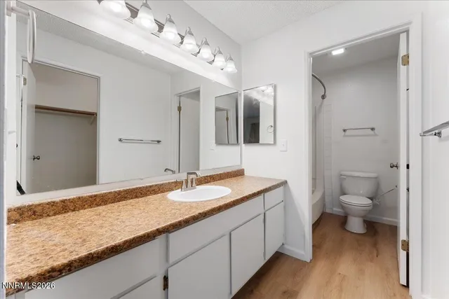 a bathroom with a granite countertop sink mirror and toilet