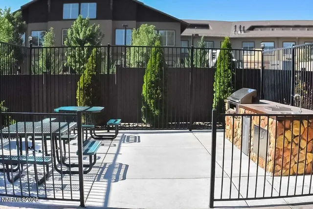 a view of a patio with table and chairs with wooden fence