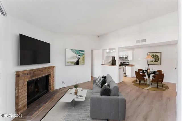 a living room with furniture a flat screen tv and a fireplace