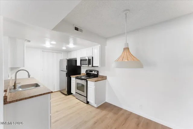 a kitchen with a sink cabinets and stainless steel appliances