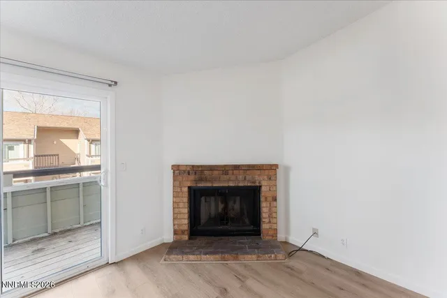 a view of an empty room with a fireplace and a window