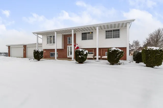 a view of a house with a barbeque and wooden stairs