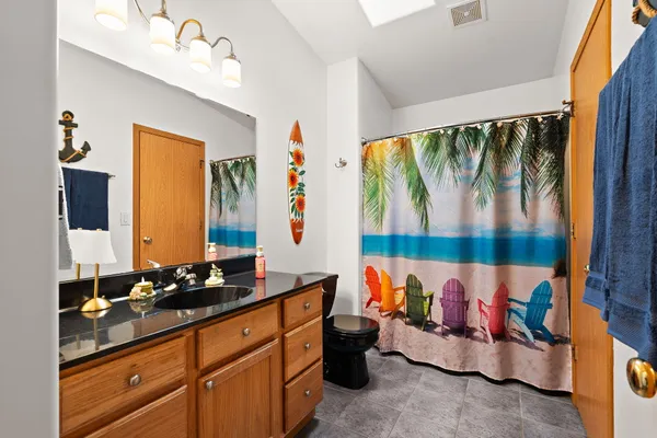 a bathroom with a bathtub shower sink vanity and toilet