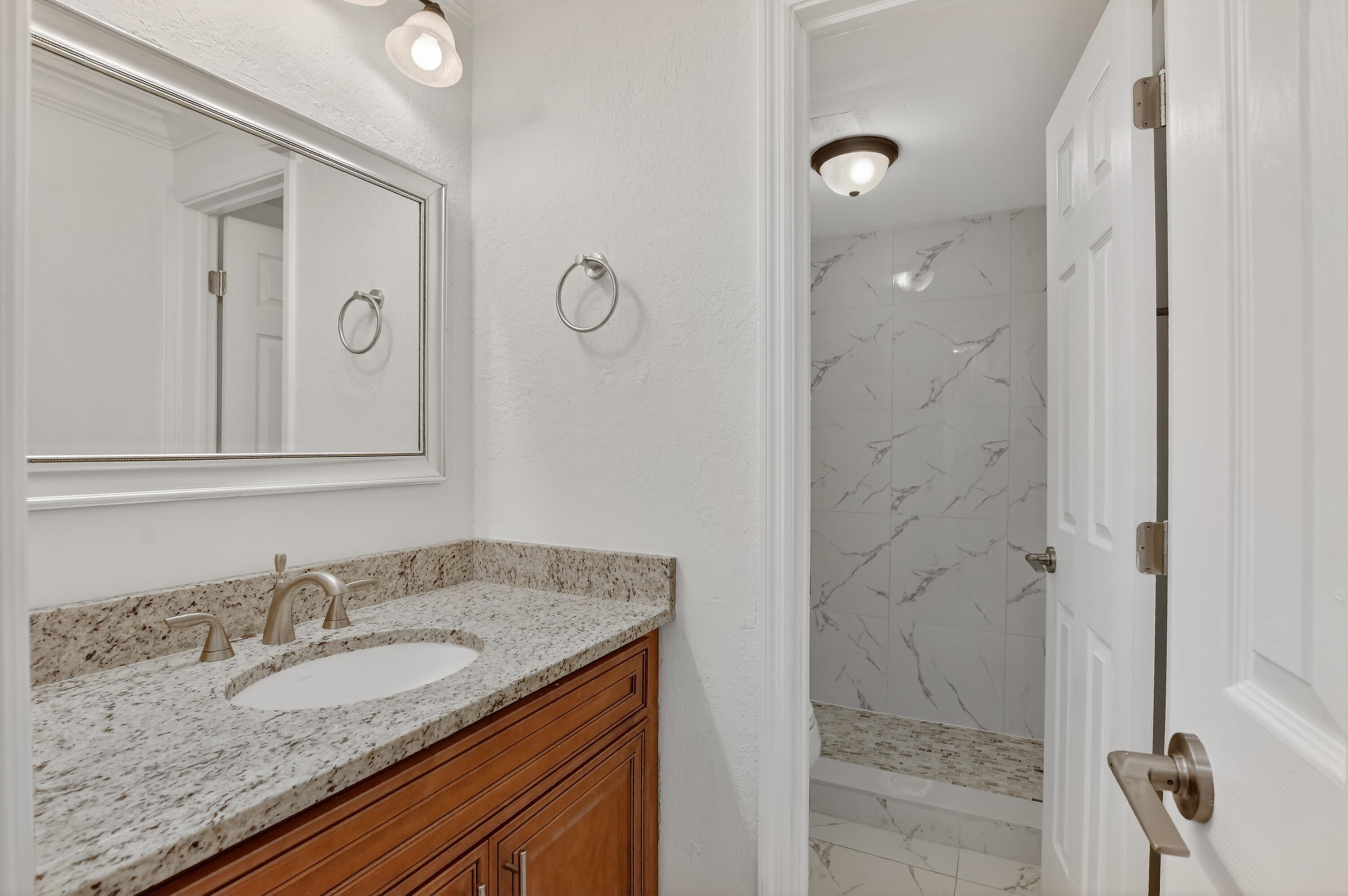 636 Northwest 13th Street, Unit 110 Boca Raton, FL 33486 - Photo 8 of 35 a bathroom with a granite countertop sink and a mirror