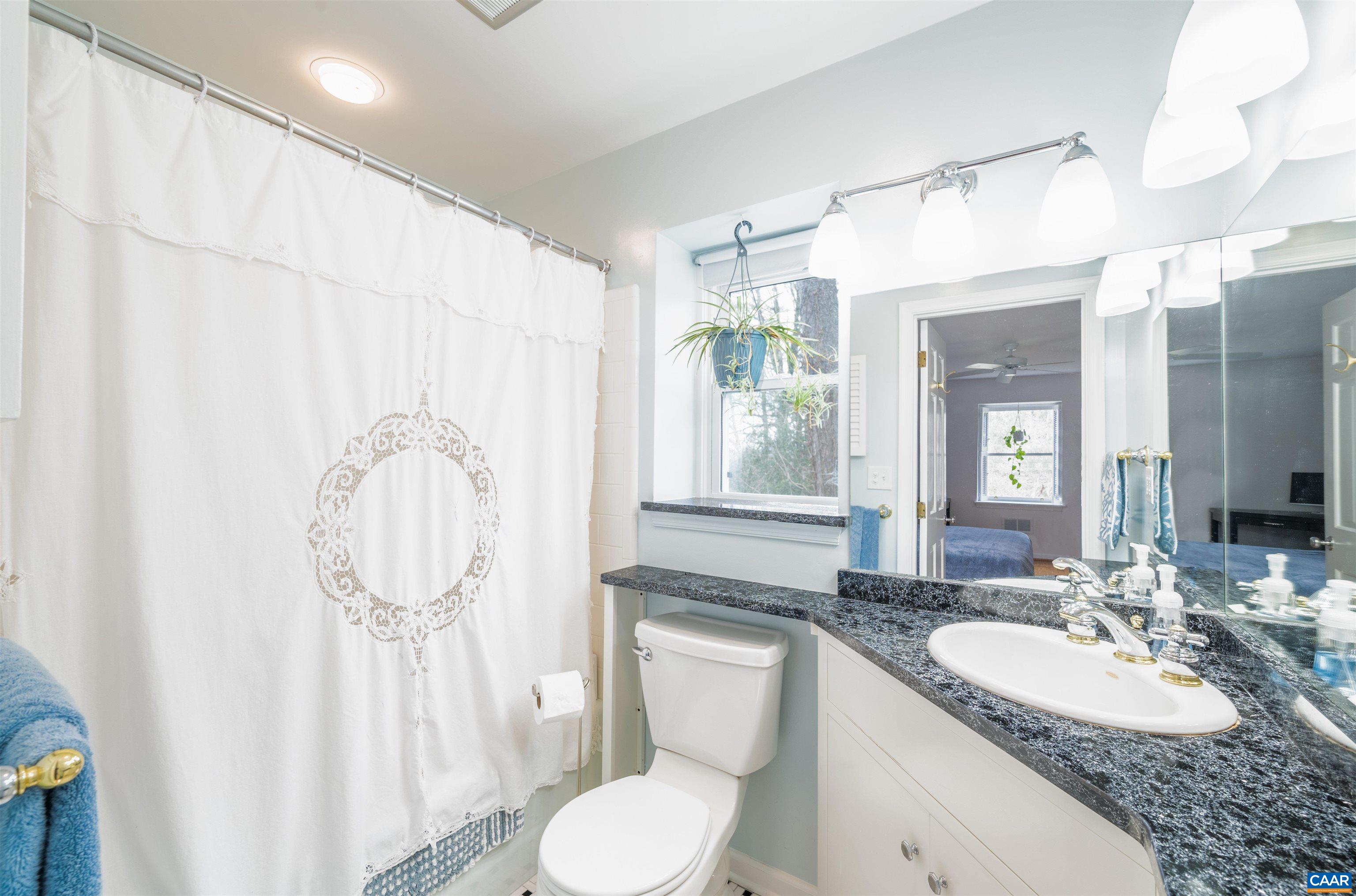 2403 Bennington Road Charlottesville, VA 22901 - Photo 18 of 31 a bathroom with a granite countertop sink mirror vanity and toilet