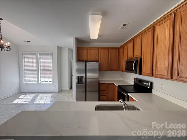 a kitchen with stainless steel appliances kitchen island granite countertop a refrigerator and a sink