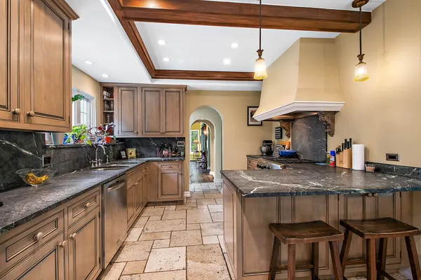 a kitchen with stainless steel appliances granite countertop a refrigerator a sink dishwasher a stove and a refrigerator