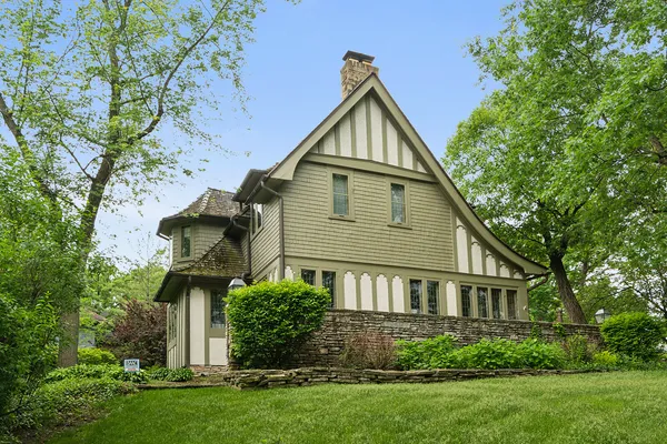 a front view of a house with a yard and trees