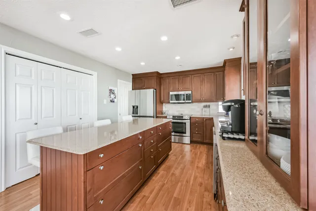 a hallway with white cabinets and wooden floor