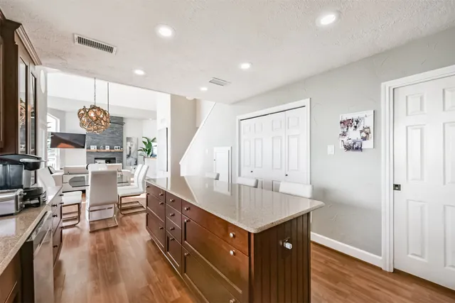 a dining hall with stainless steel appliances granite countertop a stove a sink a dining table and chairs