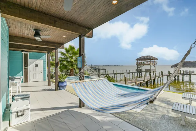 a patio with a table and chairs and potted plants