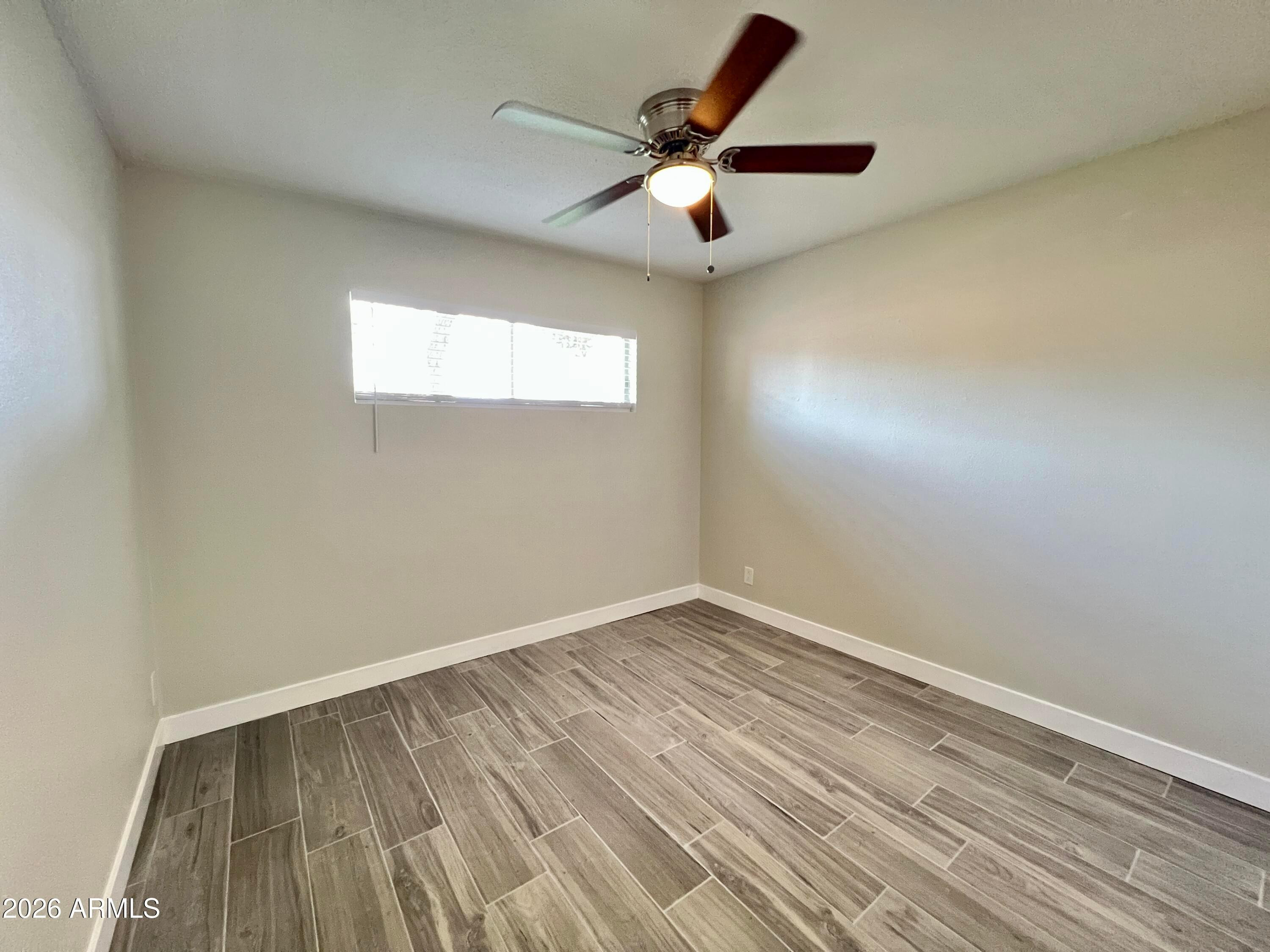 1973 East 10th Street, Unit B Tempe, AZ 85281 - Photo 4 of 6 an empty room with wooden floor and windows