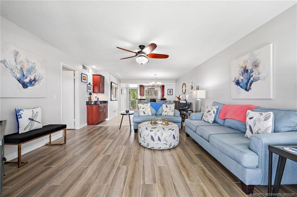 1862 Southwest Palm City Road, Unit 203 Stuart, FL 34994 - Photo 11 of 39 a living room with furniture a couch and a chandelier