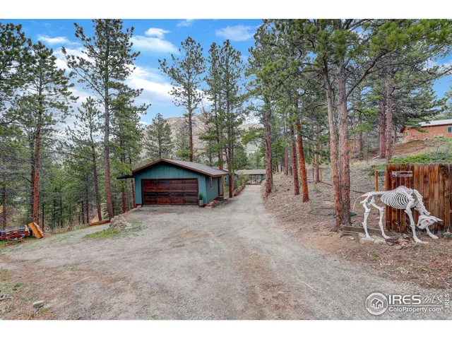 a view of a wooden house with a yard and sitting area