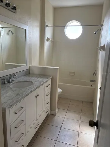 a bathroom with a granite countertop sink a toilet and a mirror
