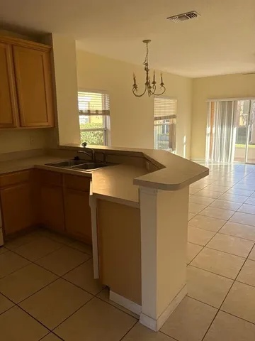 a kitchen with a sink a counter space and wooden cabinets