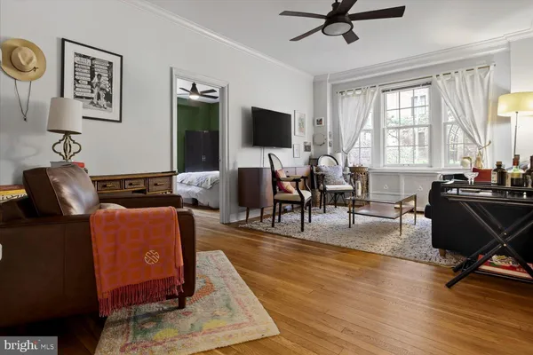 a living room with furniture a flat screen tv and a large window