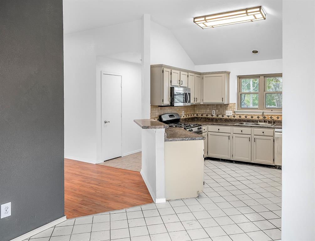 2218 Fuqua Road Rowlett, TX 75088 - Photo 11 of 30 a kitchen with white cabinets a sink stove and sink