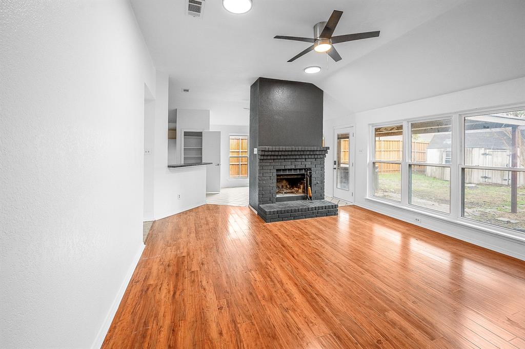 2218 Fuqua Road Rowlett, TX 75088 - Photo 5 of 30 a view of empty room with wooden floor fireplace and a window
