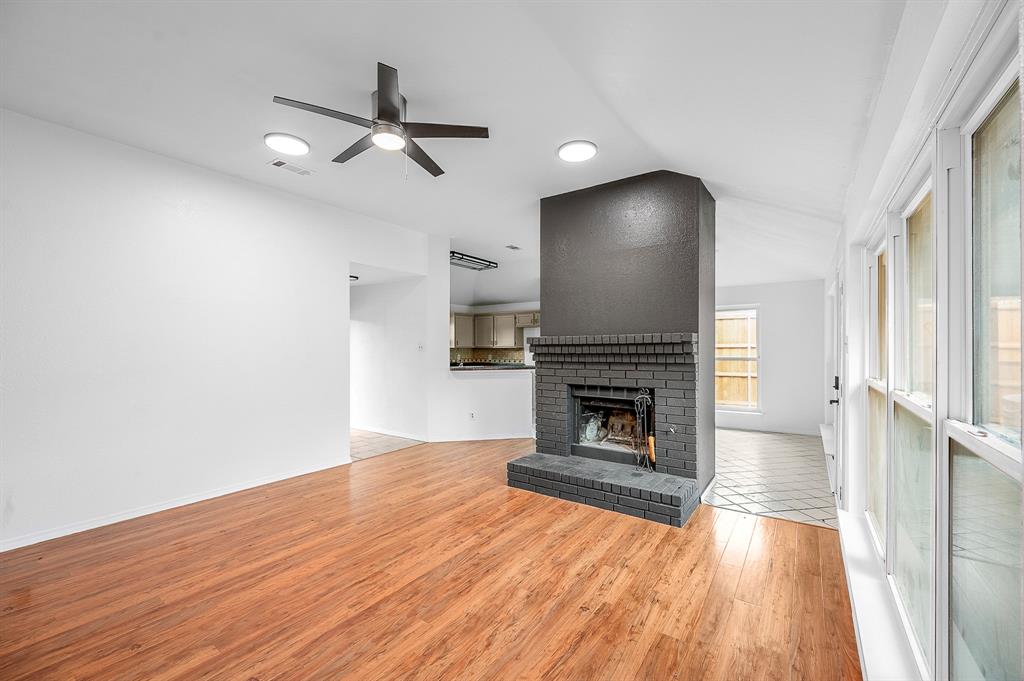 2218 Fuqua Road Rowlett, TX 75088 - Photo 7 of 30 an empty room with wooden floor fireplace and windows