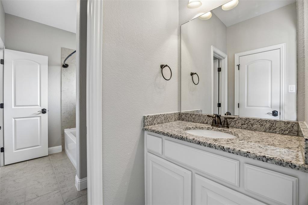134 Santa Rosa Way Irving, TX 75062 - Photo 23 of 26 Secondary bathroom with a large vanity, granite countertops, and easy access to the adjoining bedroom.