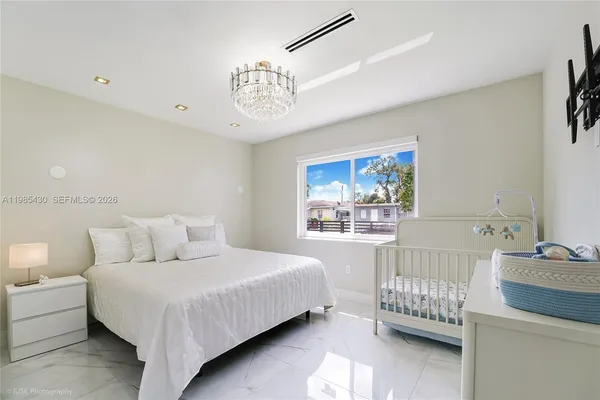 a bedroom with a bed and a chandelier