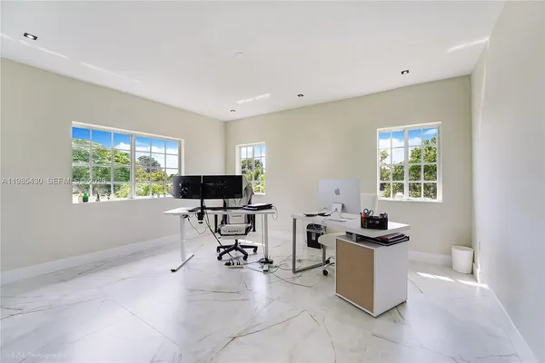 a view of a workspace with furniture and a window