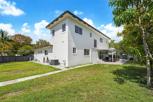 an aerial view of a house with a yard and lake view