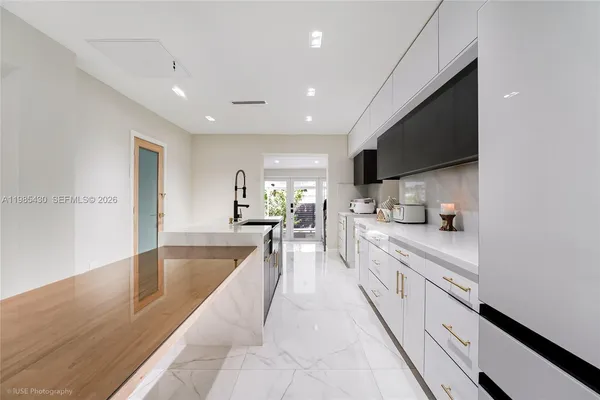a large kitchen with stainless steel appliances lots of counter space and wooden floor