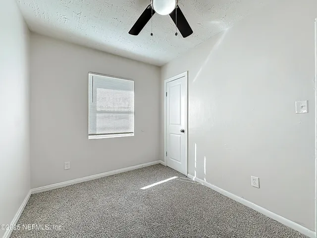 a view of a room with a ceiling fan