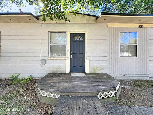 a view of house with backyard and wooden fence