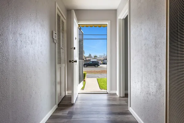an empty room with wooden floor and windows
