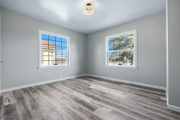 a view of an empty room with wooden floor