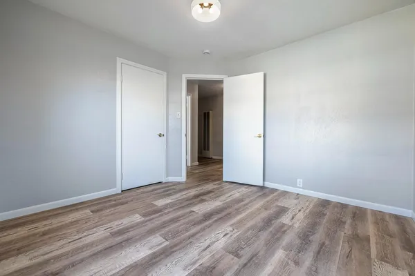 a view of an empty room with furniture and a window