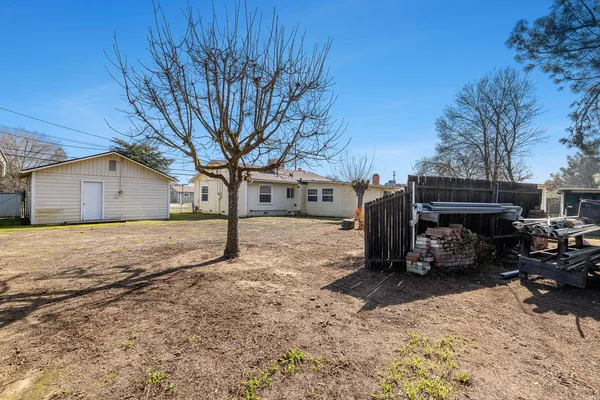 a view of a house with backyard and tree