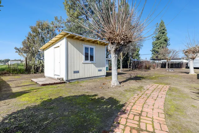 a view of a house with backyard and tree